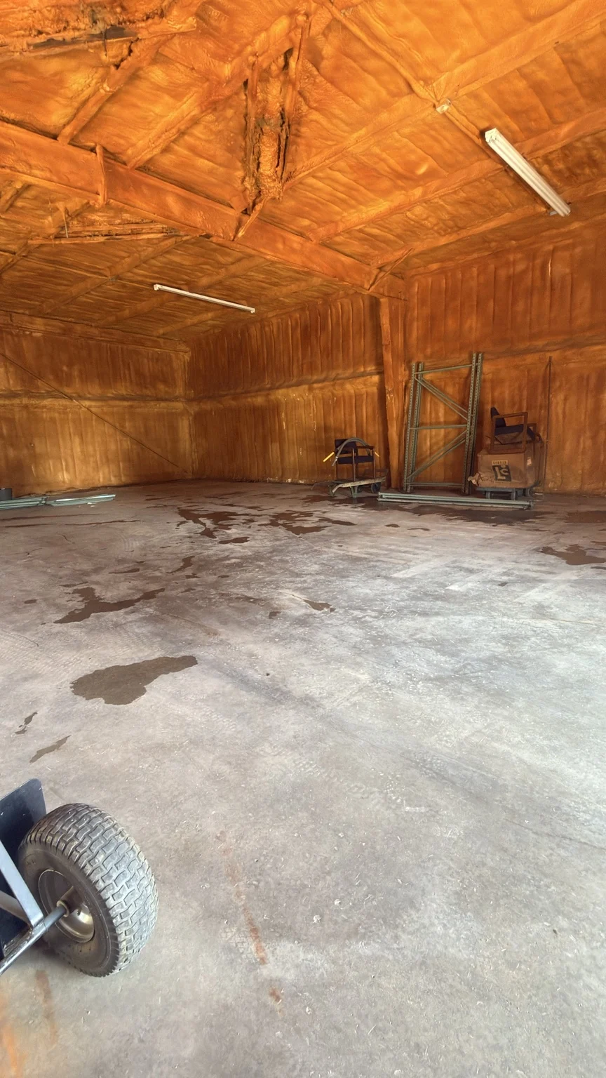 Ice House interior with spray-foam-insulated walls and ceiling, concrete floor and stored equipment