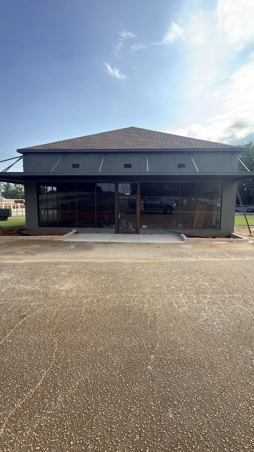 Actual sage-green office exterior and glass entrance at the Meeting Street property